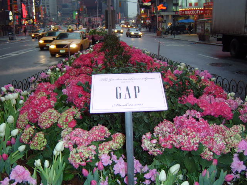 Gap sign surrounded by spring flowers. 